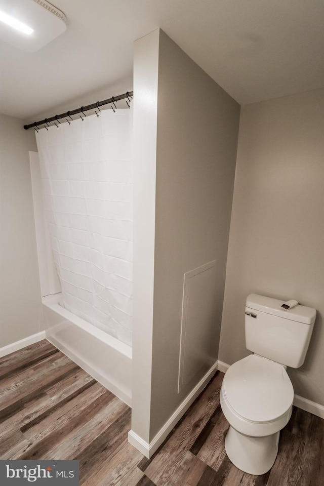 bathroom with wood-type flooring, toilet, and shower / tub combination