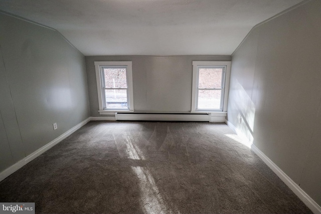 carpeted spare room with a healthy amount of sunlight, lofted ceiling, and a baseboard heating unit