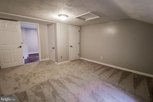 interior space featuring a textured ceiling, carpet floors, a baseboard radiator, and vaulted ceiling