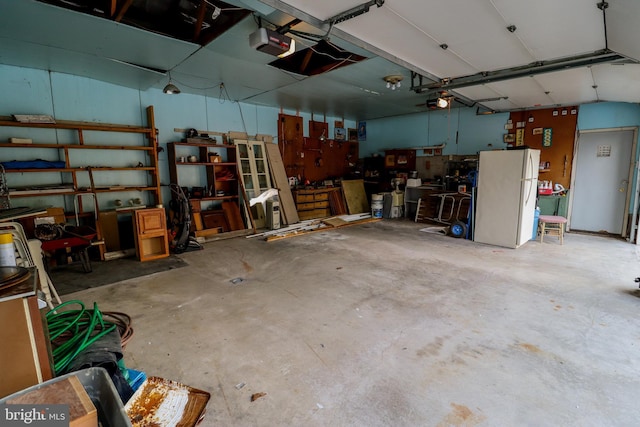 garage with a garage door opener and white refrigerator