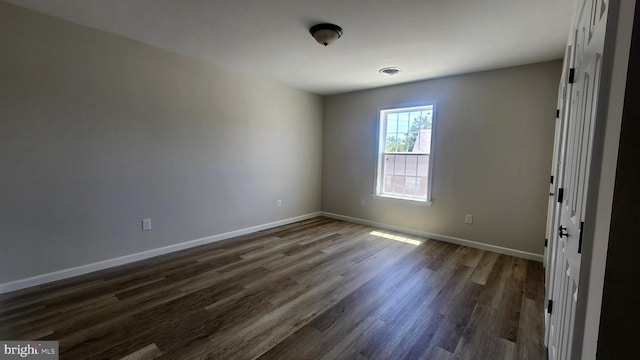 spare room featuring dark wood-type flooring