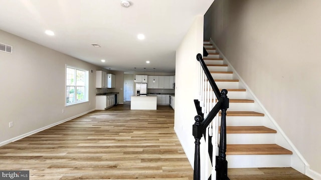 stairway with hardwood / wood-style flooring and sink