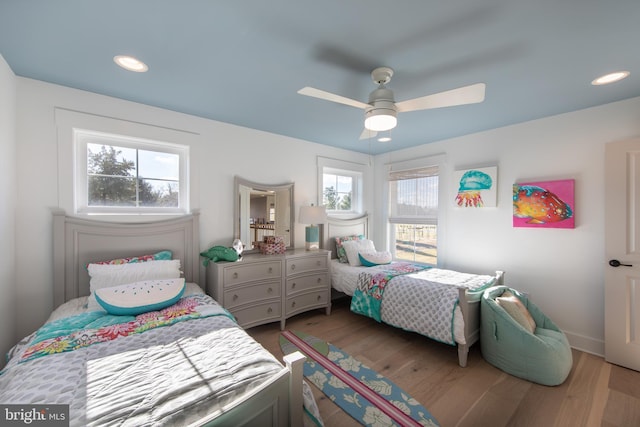 bedroom featuring hardwood / wood-style flooring, multiple windows, and ceiling fan