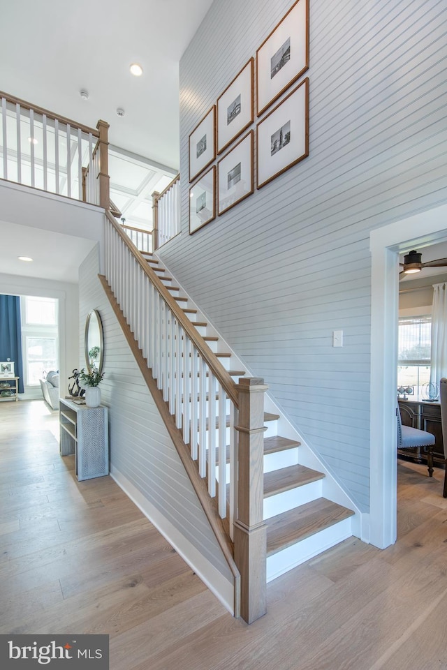 staircase with a high ceiling and hardwood / wood-style flooring