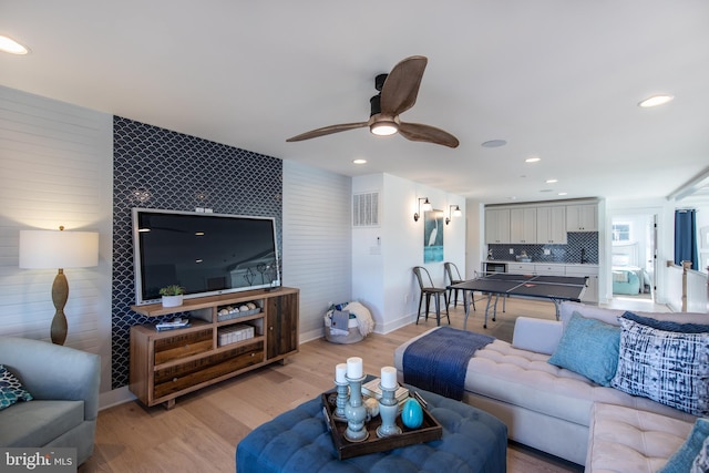 living room with ceiling fan and light wood-type flooring