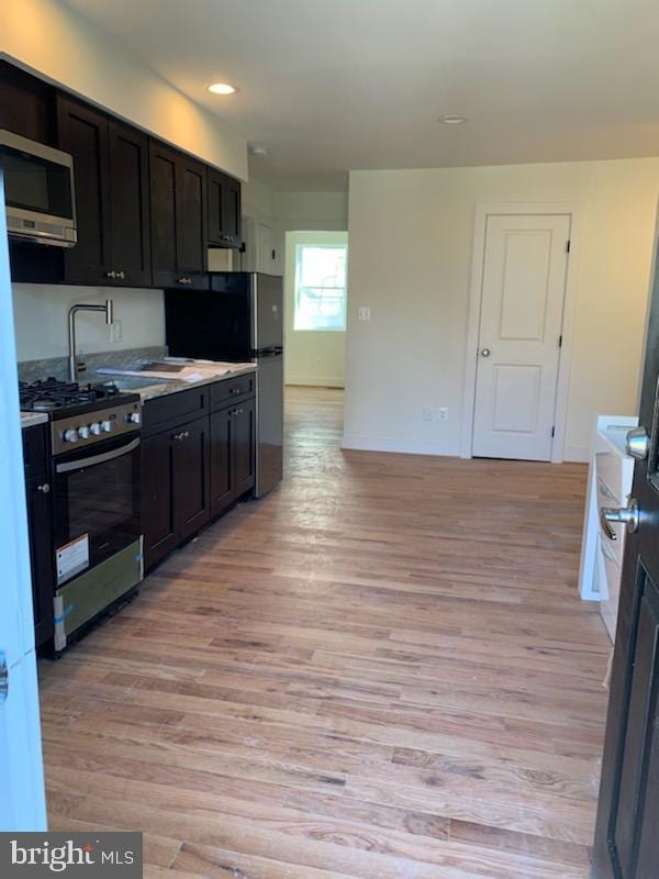 kitchen featuring sink, appliances with stainless steel finishes, and light hardwood / wood-style flooring