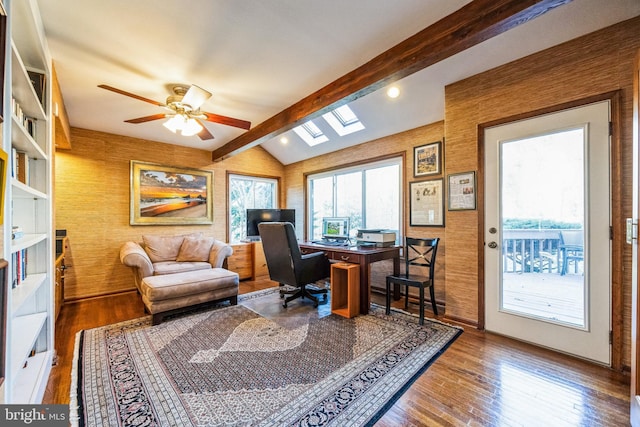 office space featuring ceiling fan, lofted ceiling with skylight, and hardwood / wood-style flooring