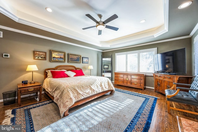 bedroom featuring a raised ceiling, ceiling fan, dark wood-type flooring, and ornamental molding