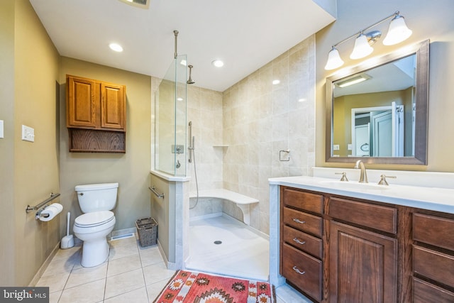 bathroom with tile patterned flooring, vanity, toilet, and walk in shower