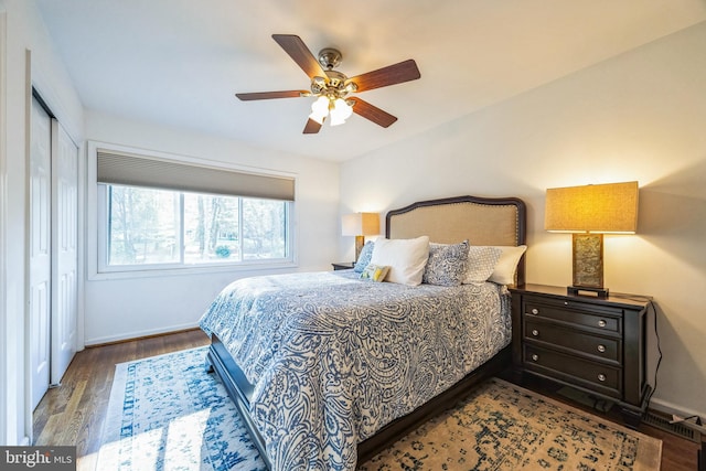 bedroom with a closet, hardwood / wood-style flooring, and ceiling fan