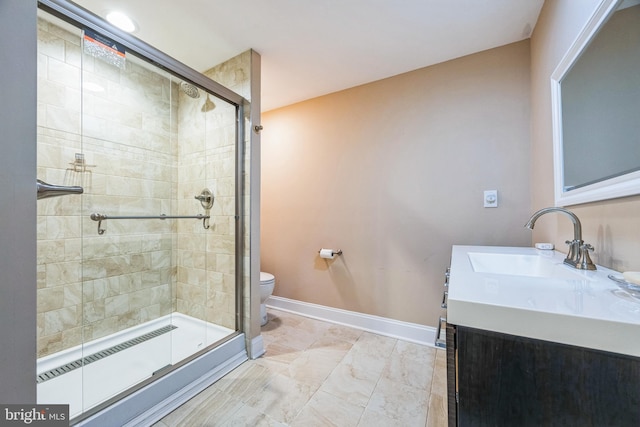 bathroom with vanity, a shower with shower door, and toilet