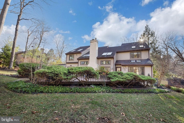 back of house featuring a lawn and a wooden deck