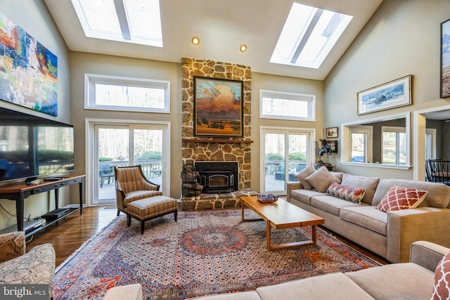 living room with hardwood / wood-style floors, a wood stove, and high vaulted ceiling