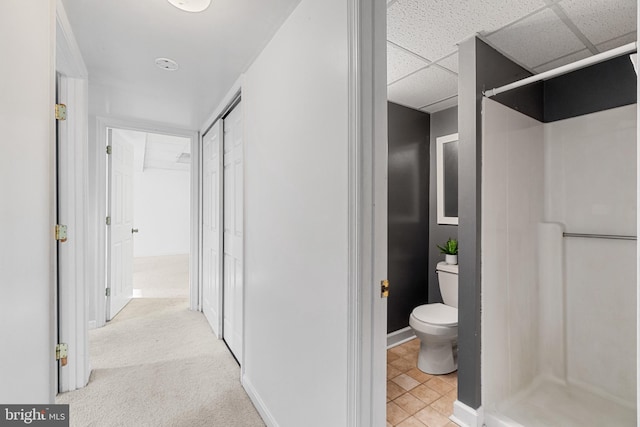 interior space featuring a drop ceiling and light carpet