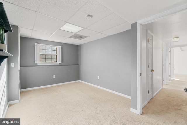 empty room with a drop ceiling and light colored carpet