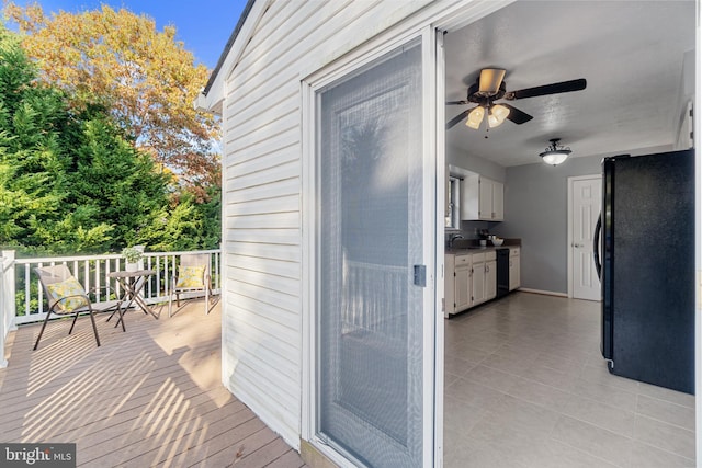 wooden terrace with a porch, ceiling fan, and sink