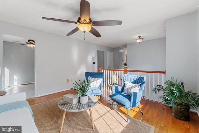 living area with light wood-type flooring and ceiling fan