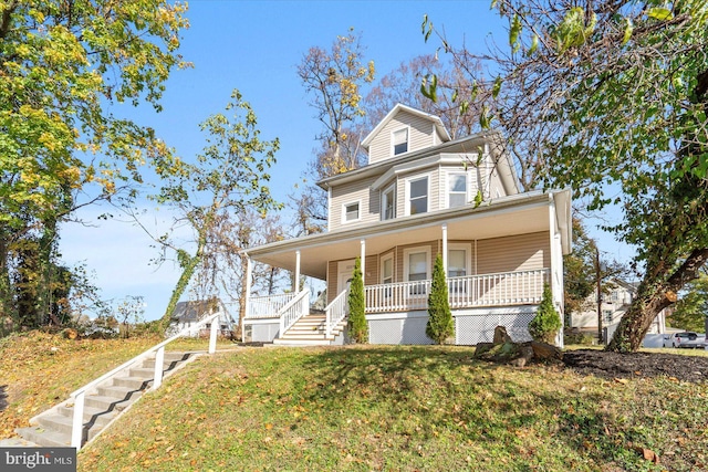 view of front facade featuring covered porch and a front yard