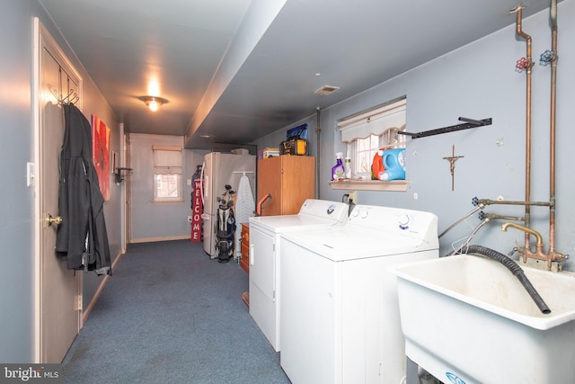 washroom featuring washer and clothes dryer, sink, and dark colored carpet