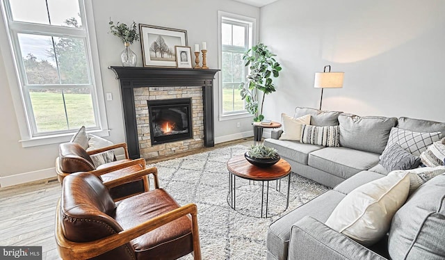 living room featuring a stone fireplace and light wood-type flooring