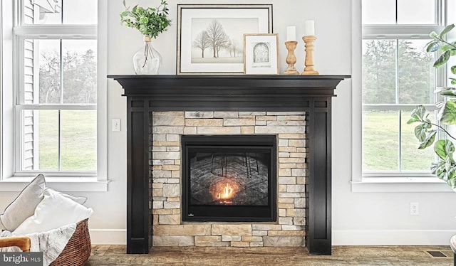 room details featuring hardwood / wood-style floors and a stone fireplace