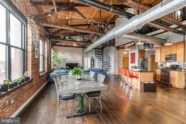 dining area with a wealth of natural light, dark hardwood / wood-style flooring, and high vaulted ceiling