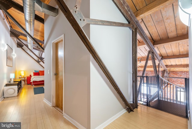 staircase with beamed ceiling, wood-type flooring, and wooden ceiling