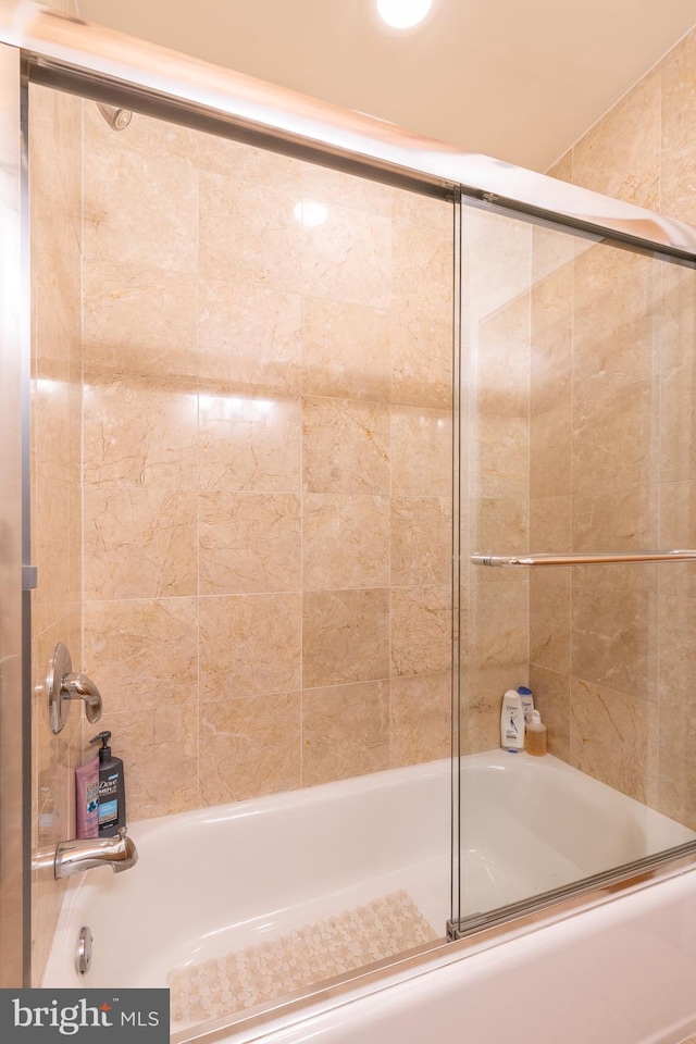 bathroom featuring bath / shower combo with glass door