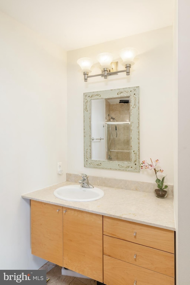 bathroom featuring hardwood / wood-style flooring, vanity, and walk in shower