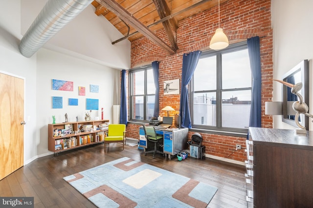 rec room featuring dark hardwood / wood-style flooring, plenty of natural light, high vaulted ceiling, and brick wall