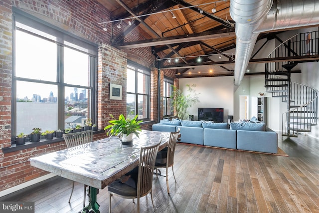 dining area featuring wood-type flooring, high vaulted ceiling, wood ceiling, and brick wall