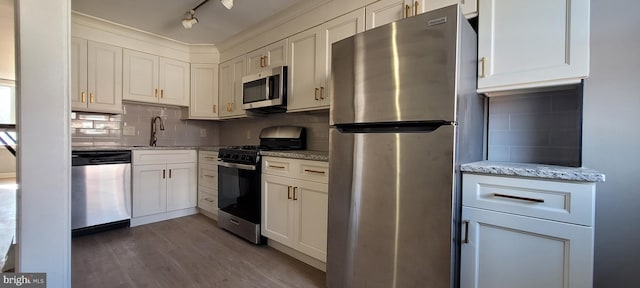 kitchen with sink, light stone counters, white cabinetry, and stainless steel appliances