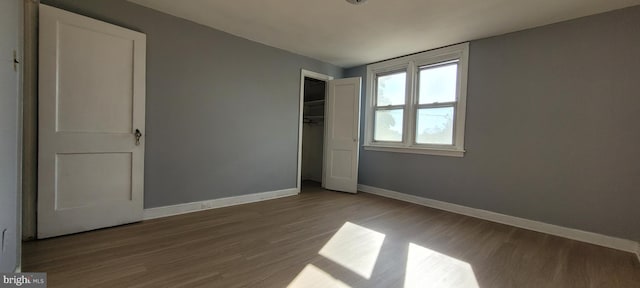 unfurnished bedroom with wood-type flooring and a closet