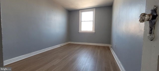 spare room featuring hardwood / wood-style floors and lofted ceiling