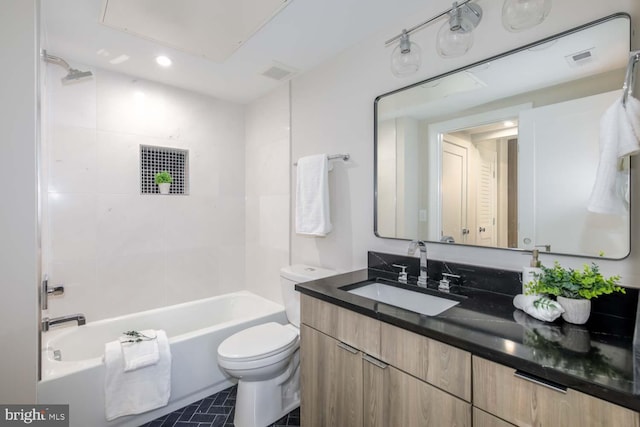 full bathroom with tiled shower / bath, vanity, and toilet