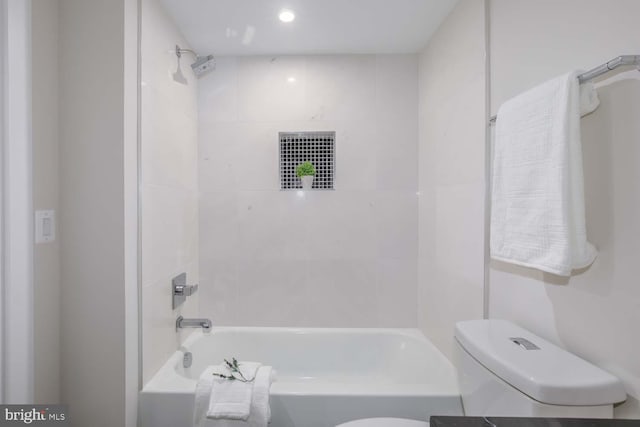 bathroom featuring tiled shower / bath and toilet