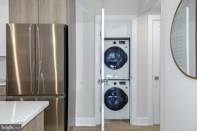 clothes washing area featuring stacked washing maching and dryer