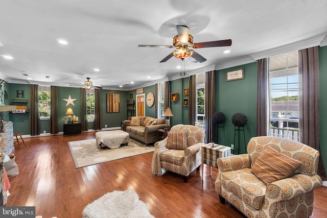 living room with crown molding, plenty of natural light, and hardwood / wood-style flooring