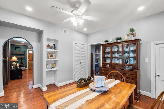 dining area with built in shelves, ceiling fan, and hardwood / wood-style floors