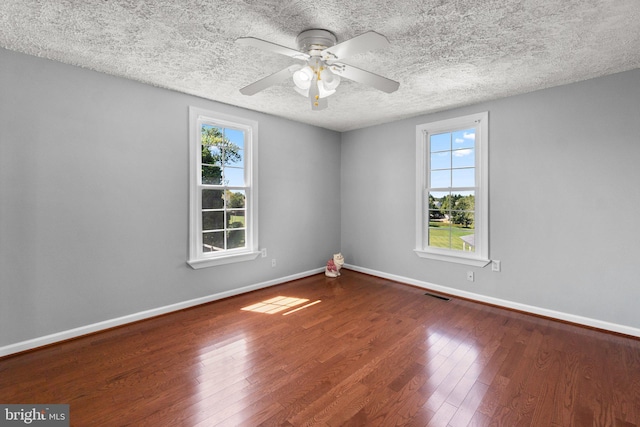 empty room featuring hardwood / wood-style floors, plenty of natural light, and a textured ceiling