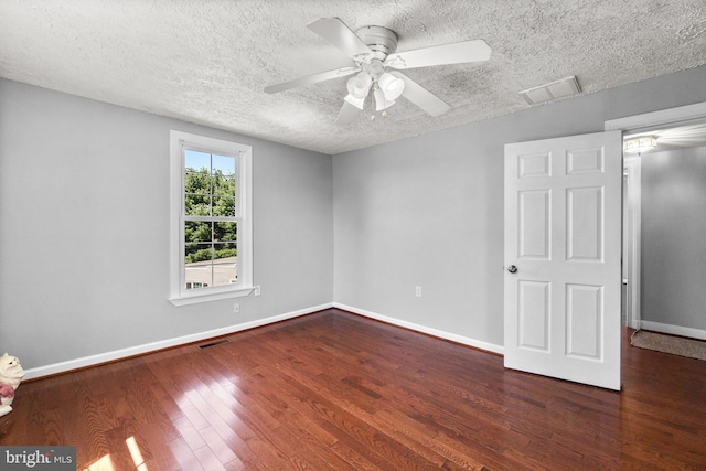 spare room with ceiling fan, a textured ceiling, and dark hardwood / wood-style flooring