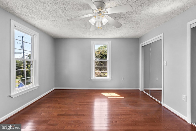 unfurnished bedroom with ceiling fan, dark hardwood / wood-style floors, and a textured ceiling