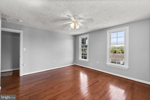 spare room featuring dark wood-type flooring, a textured ceiling, and ceiling fan