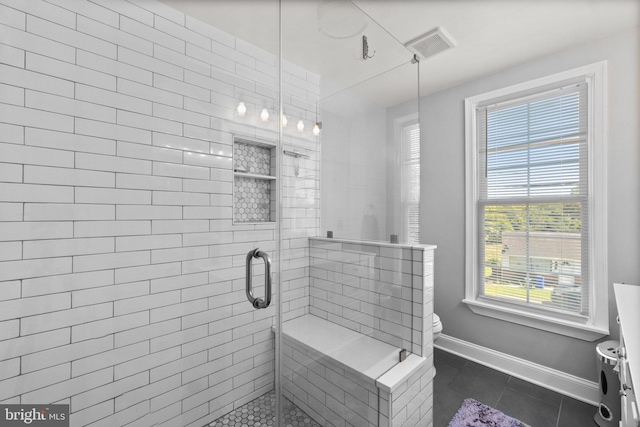 bathroom featuring tile patterned floors, toilet, and an enclosed shower