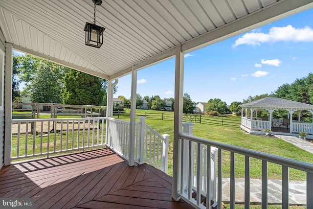 wooden terrace featuring a yard and a gazebo