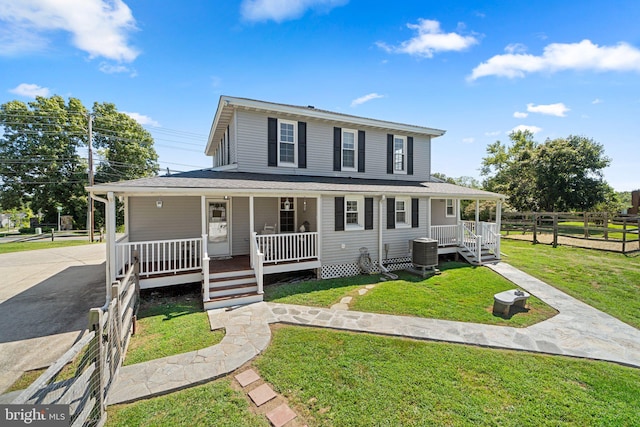 farmhouse with cooling unit, covered porch, and a front lawn