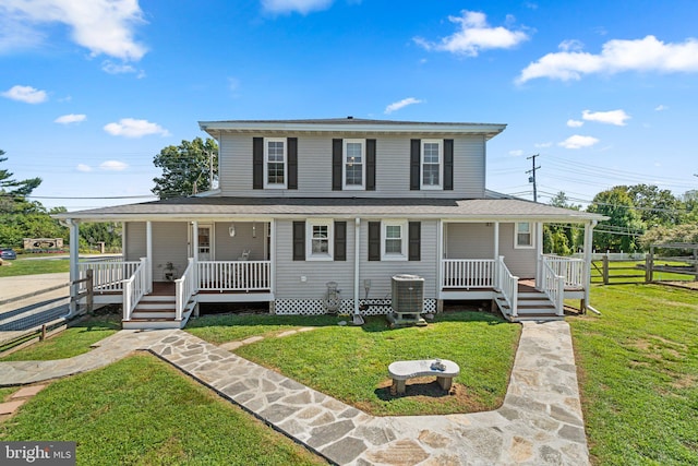 farmhouse featuring cooling unit, a front yard, and covered porch