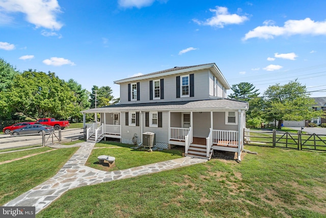 farmhouse inspired home featuring central AC unit, covered porch, and a front lawn