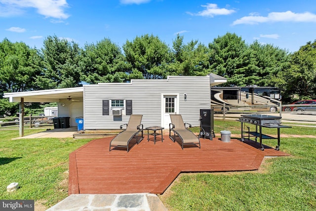 back of house featuring a wooden deck, ceiling fan, and a lawn