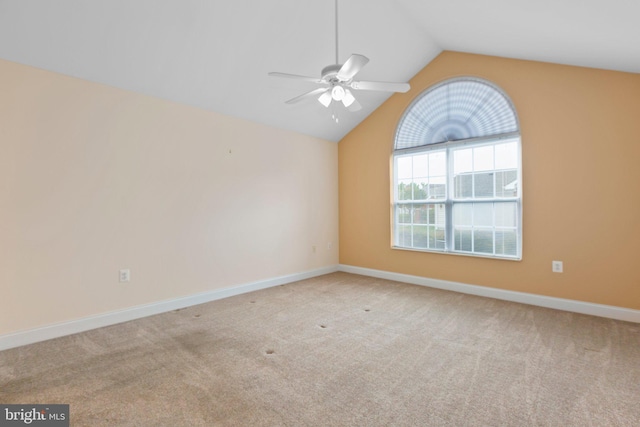 empty room with light colored carpet, ceiling fan, and lofted ceiling